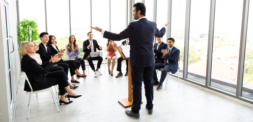 Handsome businessman coach speaker giving a presentation in conference at team meeting workshop. Male coach mentor teacher concept