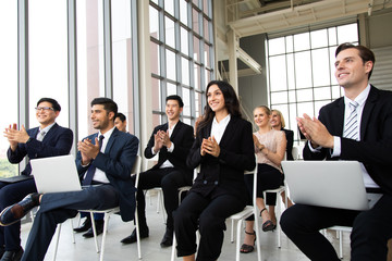 Smiling audience applauding at a business seminar. Multiethnic Business Team Meeting Seminar Training Concept