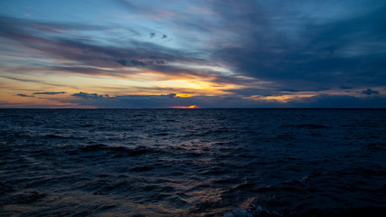 Sunset on the beach, dramatic sky and clouds.