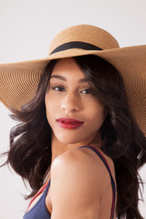 Pretty woman in straw hat looking thoughtful