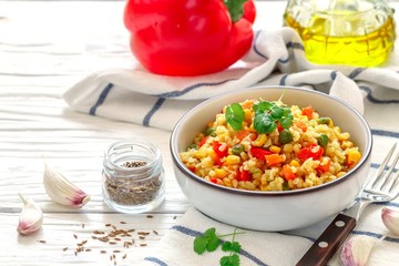 Bulgur with vegetables-onions, garlic, carrots, red bell peppers, green peas and corn. Healthy homemade organic vegan vegetarian diet food. Pilaf. useful lunch or dinner. Selective focus