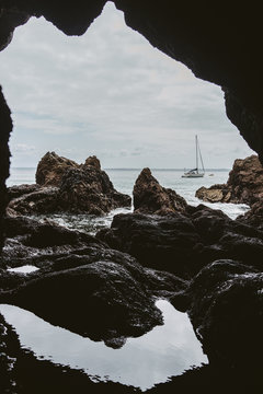 Voilier de plaisance vue depuis l'int&eacute;rieure d'une grotte de L'&icirc;le Vierge (Pointe Saint-Hernot), France, Brittany (Bretagne), Finistere, Crozon.  Parc naturel regional d'Armorique