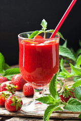 Strawberry smoothie with mint leaves on wooden rustic table