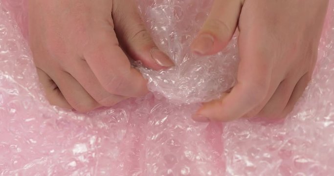Women hand clench and slam anti-stress bubble wrap