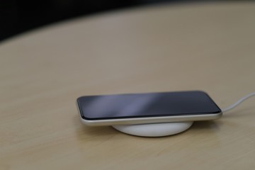 close up one smartphone on wireless charger. blur background