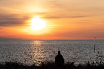silhouette of a man standing by the sea