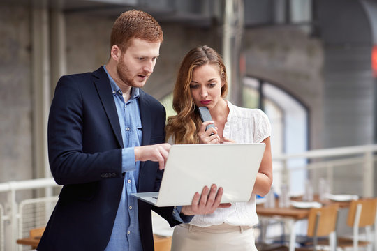 caucasian male to a female content on a laptop, showing and explaining business idea. causal  business  presentation