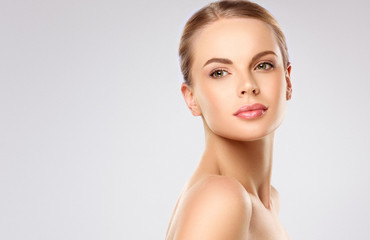 Beautiful young woman with clean fresh skin on face . Girl facial  treatment   . Cosmetology ,...