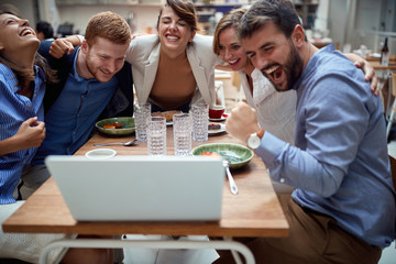 group of young caucasian people having a video call at lunch in restaurant, hugged.  fun, technology, online, internet, friends, business partners, colleagues, hugging