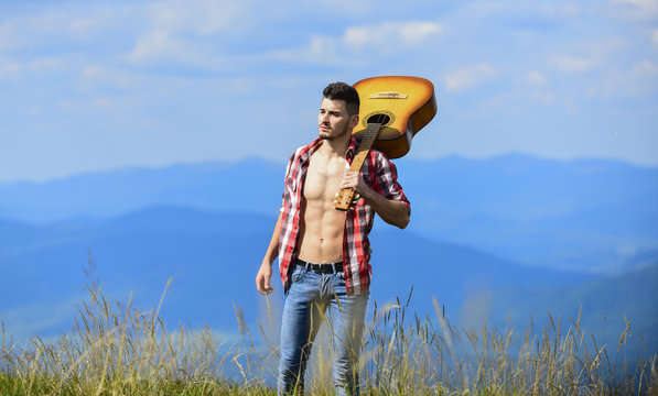 Keep calm and listen on. sexy man with guitar in checkered shirt. hipster fashion. western camping. happy and free. cowboy man with bare muscular torso. acoustic guitar player. country music song