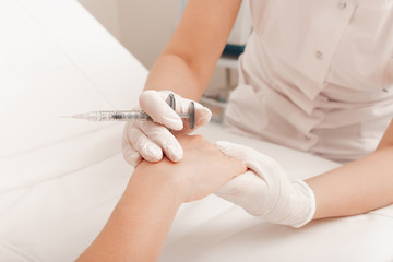 Injection of the hands. Syringe with filler for hands. Cosmetology clinic. Health care, cosmetology concept.