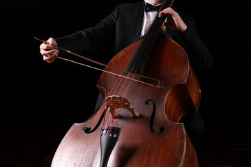 Hands of a musician with a bow playing the double bass