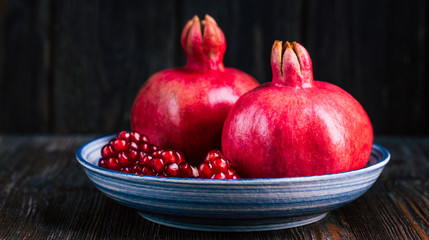 Ripe pomegranate on a wooden background, copy space