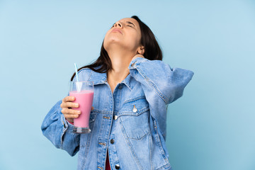 Young woman with strawberry milkshake over isolated blue background with neckache