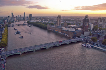 Fototapeta premium sunset in london where you can see big ben and the parliament. boats sail across the thames and it is a financial area