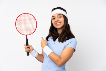 Young badminton player woman over isolated white background pointing back
