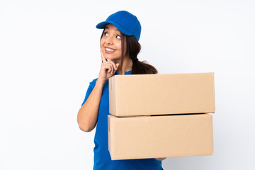 Young delivery brunette girl over isolated white background thinking an idea while looking up