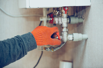 Close up of male hand closes the wick of a gas bottle, home heater, shuts off the flow. Economical...