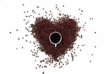 coffee heart in the center of the frame along with a Cup of black coffee. a handful of roasted coffee beans in the shape of a heart on a white background. a Cup of black coffee with brown beans