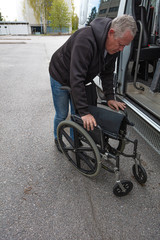 Obraz premium A man prepares a wheelchair for a disabled person