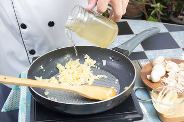 Chef pouring soup the pan for cooking mushroom cream soup