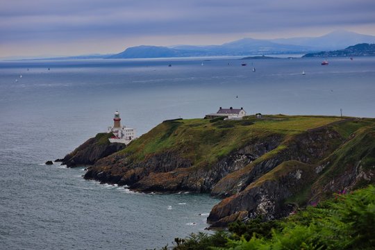 Baily Lighthouse in Howth Dublin. Peaceful picture of lighthouse spotted on trail in Howth in the afternoon. Lighthouse on green hill peninsula. 