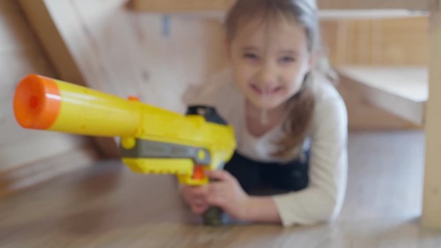 Young girl with toy gun game shoot on the camera