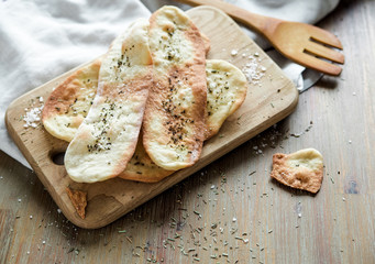 Thin italian flatbread with spices.Thin tortillas.Traditional italian focaccia with olive oil and salt.Wooden board.