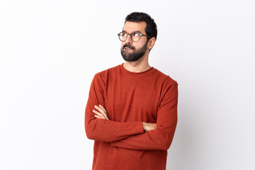 Caucasian handsome man with beard over isolated white background with confuse face expression