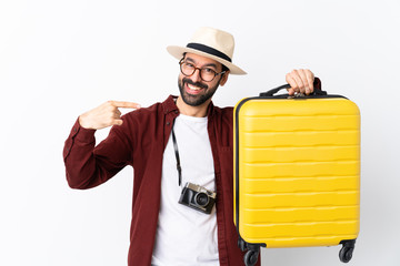 Traveler man man with beard holding a suitcase over isolated white background