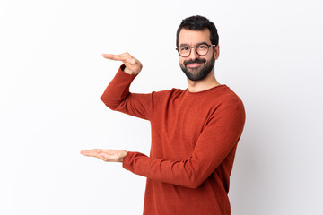 Caucasian handsome man with beard over isolated white background holding copyspace to insert an ad