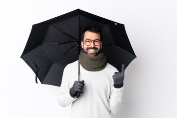 Caucasian handsome man with beard holding an umbrella over isolated white wall pointing up a great idea