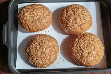 Hamburger bun with sesame seeds on the tray.