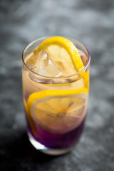 Gin based colorful cocktail with lemon and lavender liqueur on the rustic background. Selective focus. Shallow depth of field.
