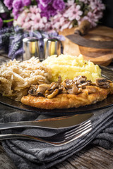 Breaded pork chop with mushrooms.