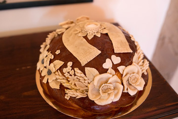 Ukrainian wedding loaf decorated with flowers. Lush round bread.