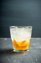 Old fashioned beverage with orange slices on rustic background. Selective focus. Shallow depth of field.