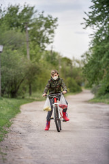 Fototapeta premium Masked boy on a bicycle in red boots on colorful background . White medical mask isolated. Virus protection concept. Male cartoon character. Beautiful portrait for lifestyle design.