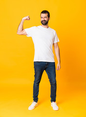 Fototapeta na wymiar Full-length shot of man with beard over isolated yellow background doing strong gesture