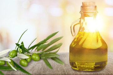 Aroma oil in the jug and olives on the desk