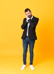 Full-length shot of business man over isolated yellow background making sleep gesture in dorable expression