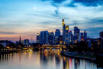 Frankfurt skyline lights at dusk with evening moon