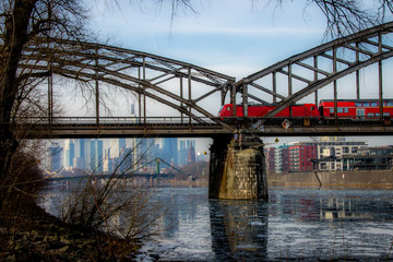 German red train crossing a bridge Frankfurt in front of the Frankfurt skyline