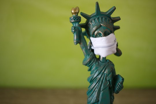 Statue of liberty figure with a mask on white