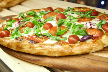 pizza with cherry tomatoes arugula leaves and mozzarella 
