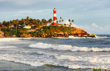Fototapeta na wymiar Lighthouse on the rocks near the ocean in Kovalam, Kerala, India