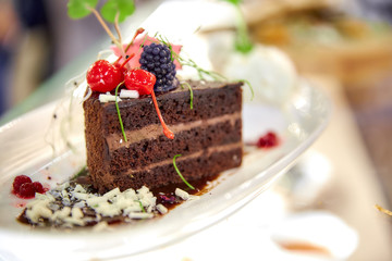 four round profiteroles cakes with colorful sprinkles on a white dish