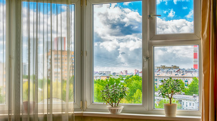 The window in the room against the backdrop of the cityscape.