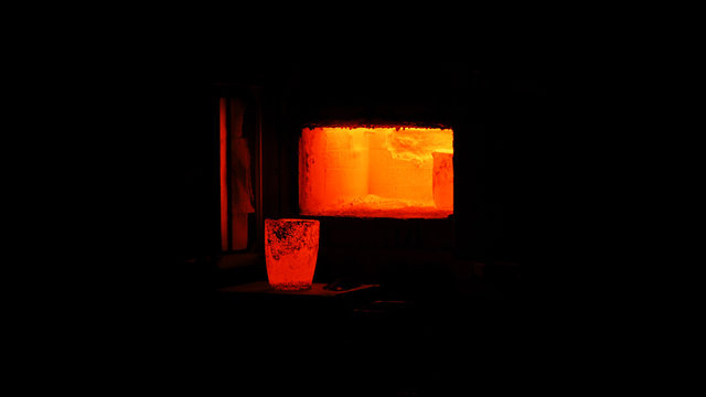 Glowing hot crucible by an open furnace door