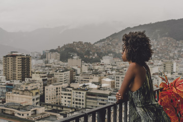 Side view of a thoughtful young Brazilian woman with a curly Afro hair pensively looking on a dull...